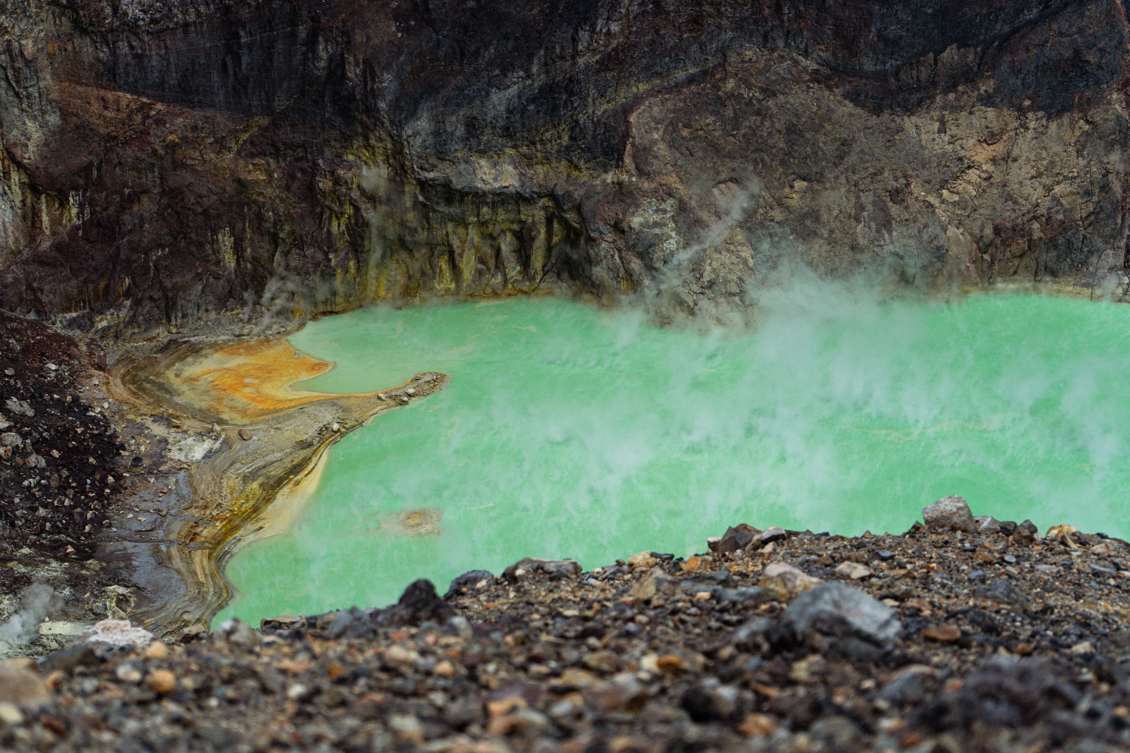Vibrant green volcanic crater lake, illustrating a CO₂-saturated lake prone to limnic eruptions.